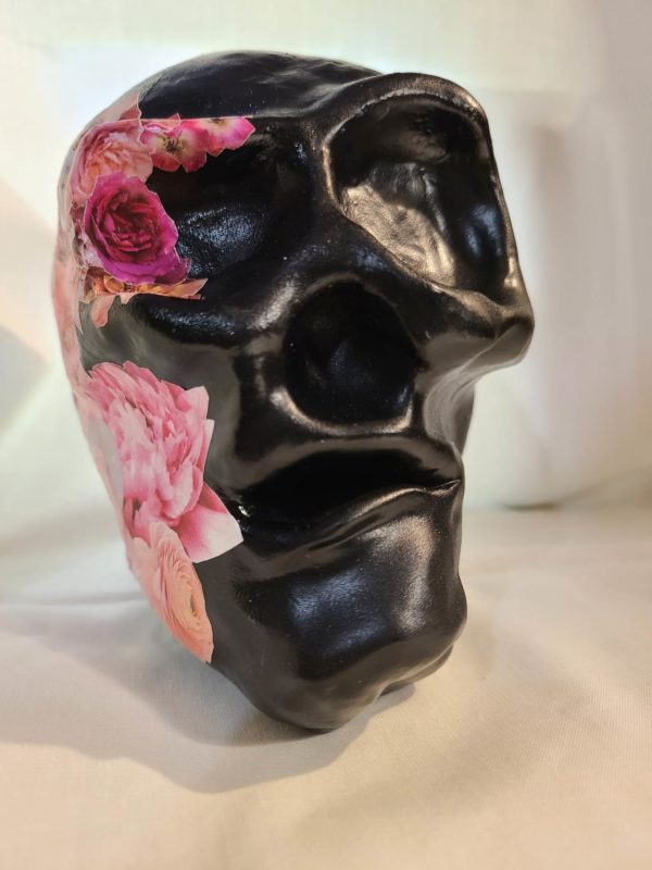 Tête de mort noire et fleurs roses